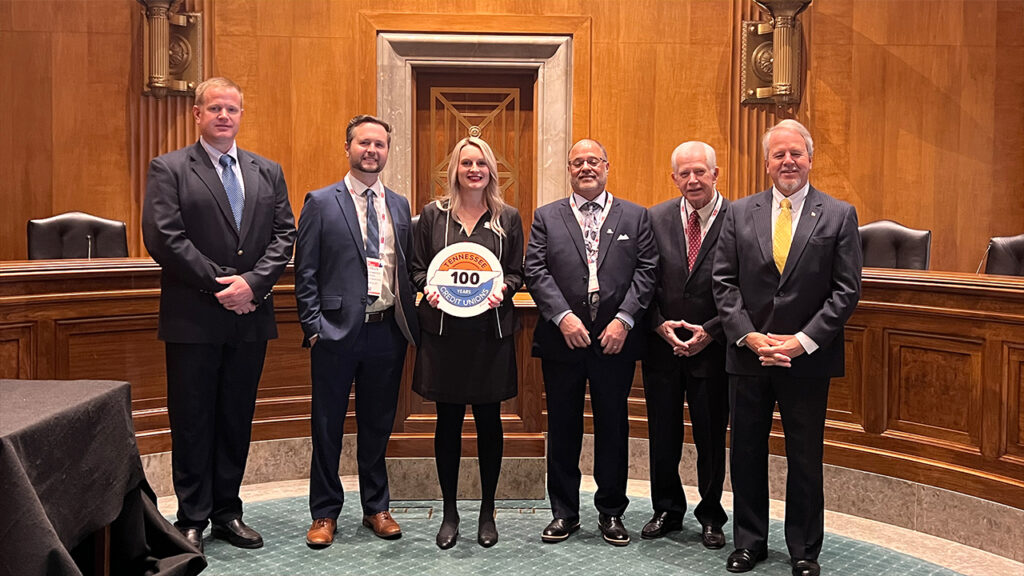 Kameran Laux, holding sign, was Tennessee's 2023 GAC crasher. Here she stands with US Community Credit Union leaders and volunteer board members during a Hike the Hill session.