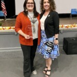 Jessica Grostic, president and CEO, Copper Basin Federal Credit Union, wears the credit union umbrella man on her skirt while presenting an employee award.
