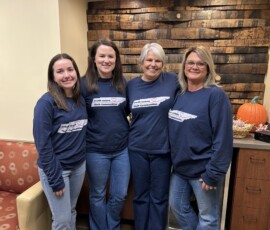 Jack Daniel Employees' Credit Union employees take a team photo before the Grocery Giveaway. From left are—Carly Hill, Whitney Williams, Dawn Sullenger and Christy Dorsett.