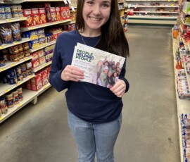 Carly with Jack Daniel Employees' Credit Union holds the People Helping People brochures.