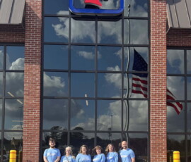 Credit union volunteers stand outside of the Ocoee Food City.