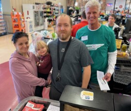 David LeVeau, president and CEO of Northeast Community Federal Credit Union, awards free groceries to a young family at the Food City in Elizabethton.