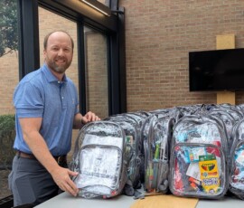 Chris Evans, executive vice president of Southern Security Credit Union, stacks filled backpacks for the Youth Villages Backpack Heroes Campaign.