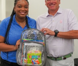 Taylyn Hill, event and brand coordinator at Southern Security Credit Union, and Terry Baker, chief lending officer of Southern Security Credit Union, display a backpack filled with school supplies for the Youth Villages Backpack Heroes Campaign.